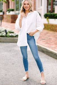Cotton button-down white top Oversized fit High-low hemline Perfect with jeans or as a coverup Casual chic style